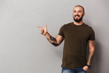 Cam poz ellerinde dövmeli tıraşsız neşeli adam görüntüsünü