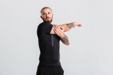 Kollarını vücut germe üzerinde dövmeli genç beyaz adam ve