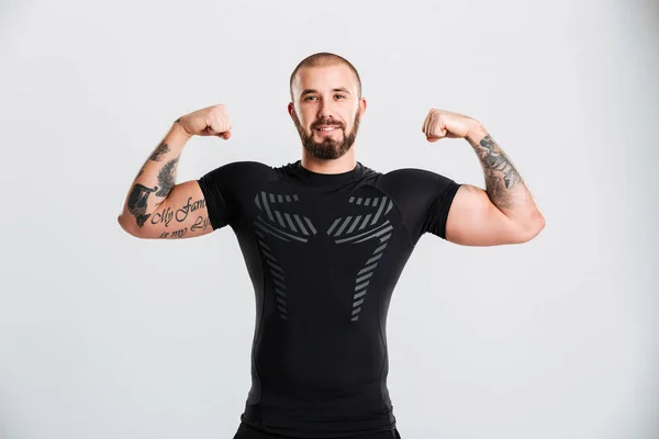 Retrato de hombre fuerte en ropa deportiva negra con tatuaje en su ar — Foto de Stock