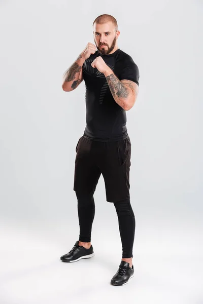 Imagen completa de boxeador concentrado en ropa deportiva negra posi — Foto de Stock