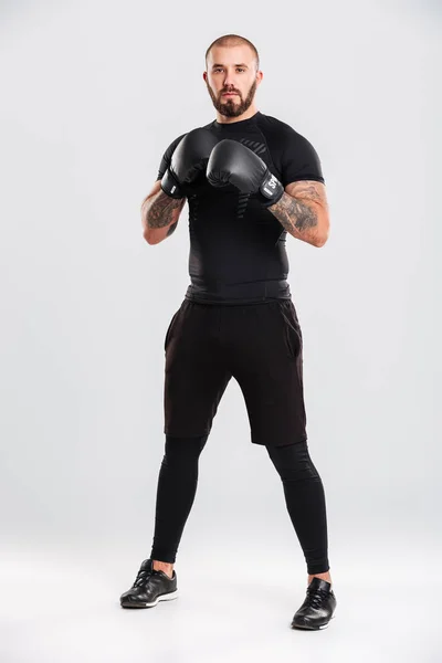 Full-length foto van geconcentreerde bokser in zwarte sportkleding en — Stockfoto