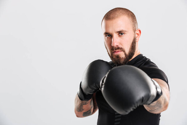 Closeup image of serious bearded man with tattoos on his arms pu