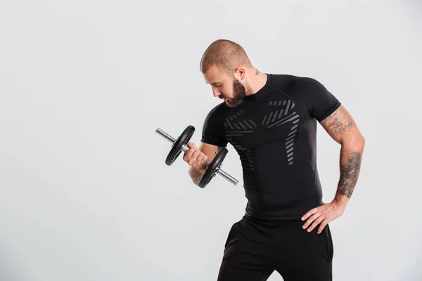 Foto i profil av stark bodybuilder i svarta sportiga kläder — Stockfoto