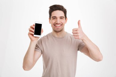Bej t-shirt holding cep telefonu c ile esmer adam fotoğrafı