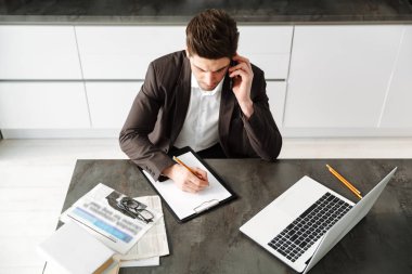 Konsantre genç işadamı cep telefonuyla konuşmaya çalışma.