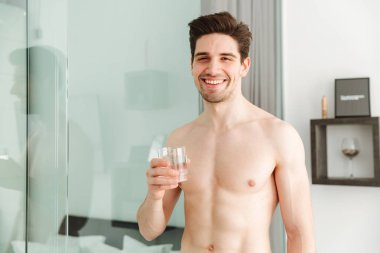 Neşeli çıplak adam evde ayakta