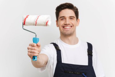 Boya rulo gösterilen ve kameraya bakarak mutlu erkek Oluşturucu