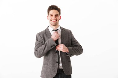 Ceketli iş adamı gülümseyen kravatını düzeltir