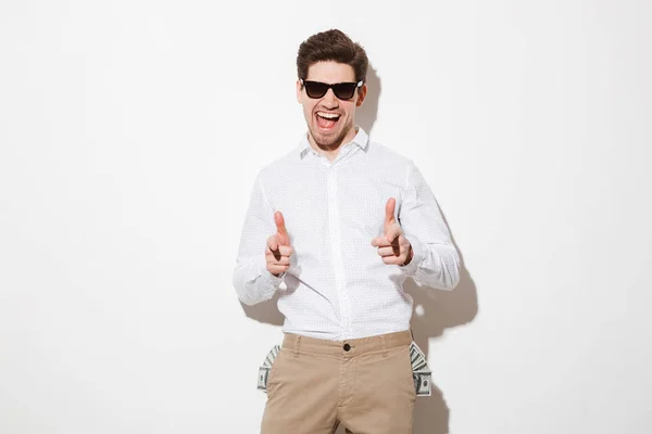 Perky man in black sunglasses pointing index fingers on camera w — Stock Photo, Image