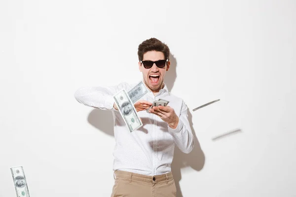 Portrait of a happy young man in sunglasses throwing — Stock Photo, Image