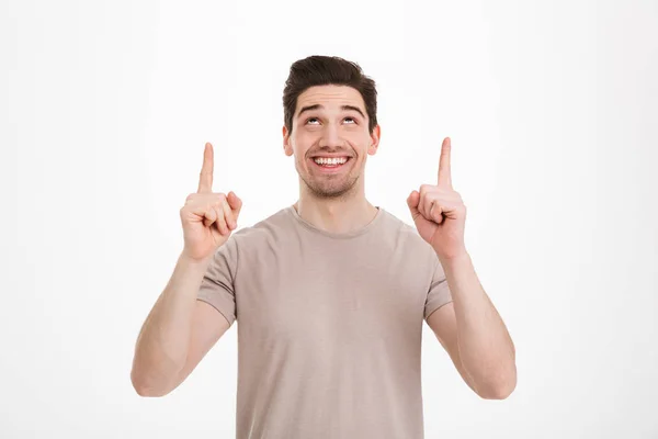 Positive brunette man 30s wearing beige t-shirt gesturing finger — Stock Photo, Image