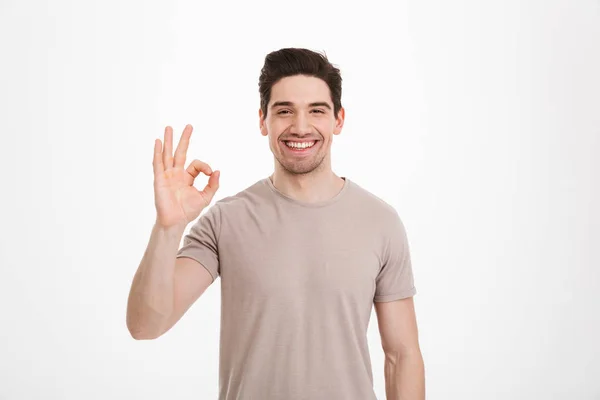 Photo of content unshaved guy 30s wearing beige t-shirt gesturin — Stock Photo, Image