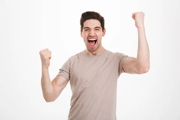 Foto van blij gelukkig man 30s in casual t-shirt schreeuwen en — Stockfoto