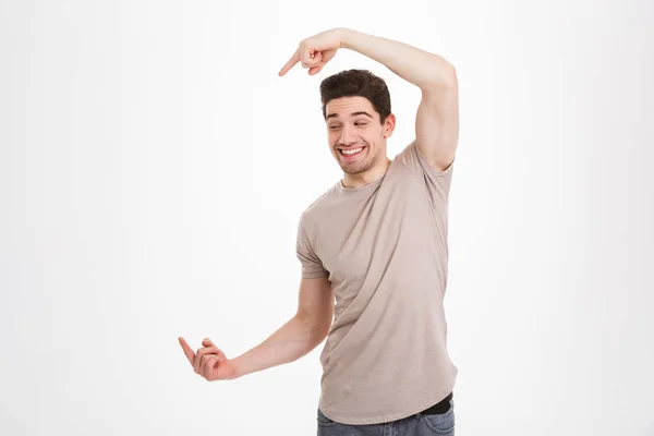 Foto z veselé pohledný muž 30s nosí béžové tričko pointin — Stock fotografie