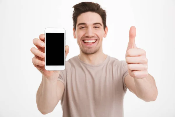 Foto de hombre en camiseta beige demostrando copyspace negro scre —  Fotos de Stock