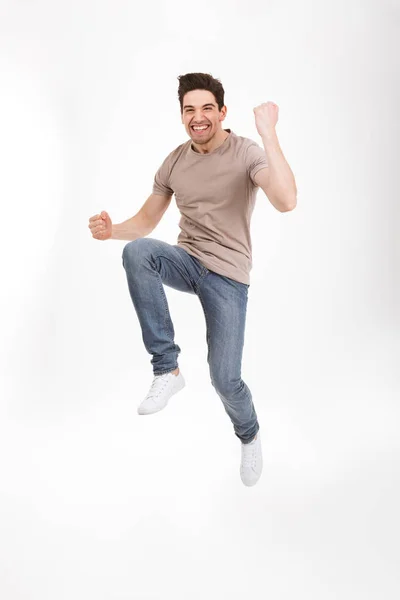 Foto de longa duração do homem animado 30 anos em t-shirt casual e jeans — Fotografia de Stock