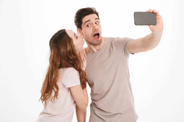 Retrato de una feliz pareja joven tomando una selfie juntos — Foto de Stock