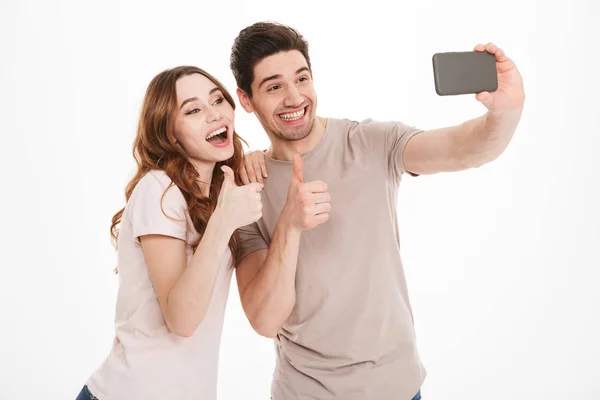 Retrato de um jovem casal feliz mostrando polegares para cima — Fotografia de Stock