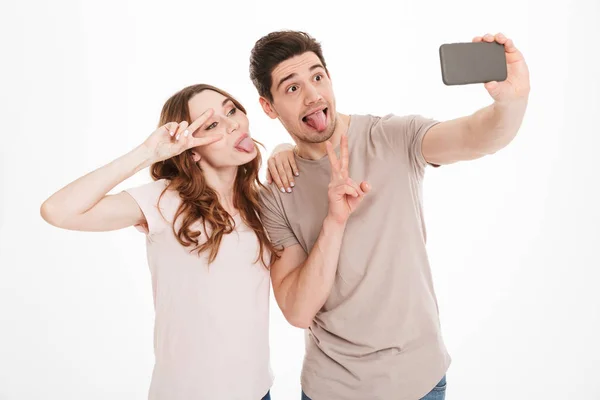 Retrato de um jovem casal engraçado tirando uma selfie — Fotografia de Stock