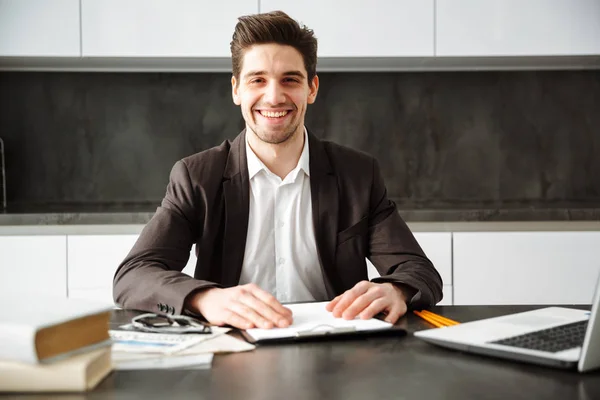 Joyeux jeune homme d'affaires travaillant à l'intérieur — Photo