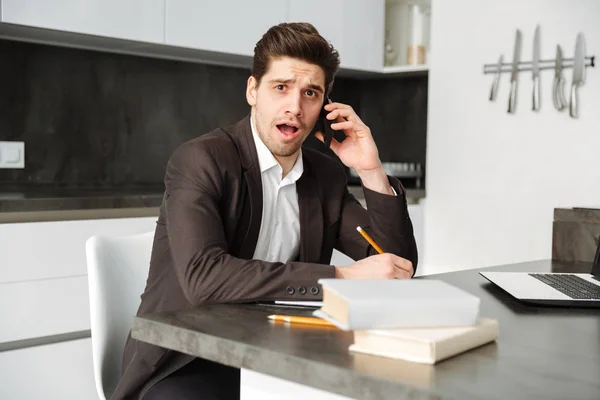 Jovem empresário chocado falando por telefone celular . — Fotografia de Stock