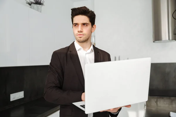 Ernstige jonge zakenman laptopcomputer gebruikt. — Stockfoto