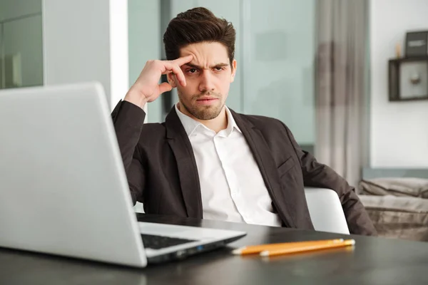 Joven empresario serio sentado en casa — Foto de Stock