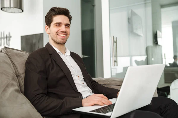 Feliz joven hombre de negocios en el hogar usando ordenador portátil . — Foto de Stock