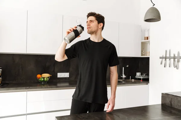 Handsome young man drinking water. — Stock Photo, Image