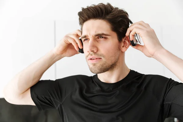 Un joven guapo con auriculares. Mirando a un lado . — Foto de Stock