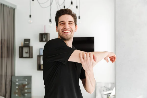 Schöner junger Mann, der in seinem Haus steht — Stockfoto