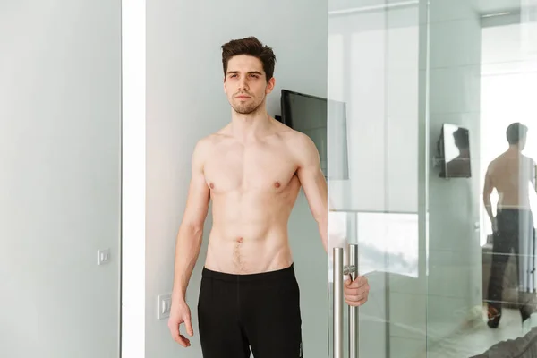 Vážné nahý muž stojící inoors — Stock fotografie
