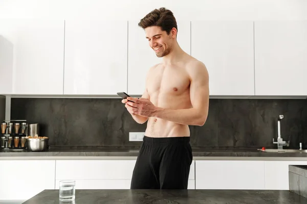 Happy cheerful naked man standing in kitchen — Stock Photo, Image