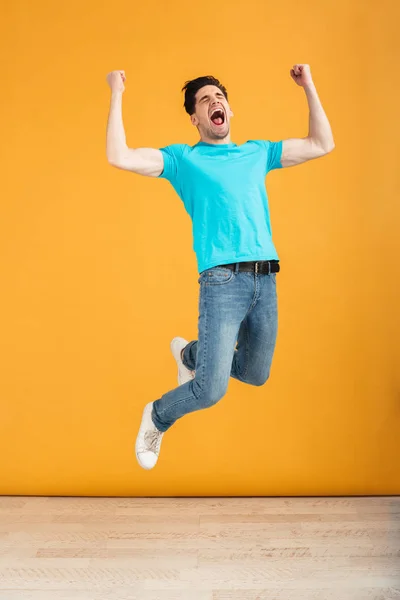 Full längd porträtt av en glad ung man hoppa — Stockfoto