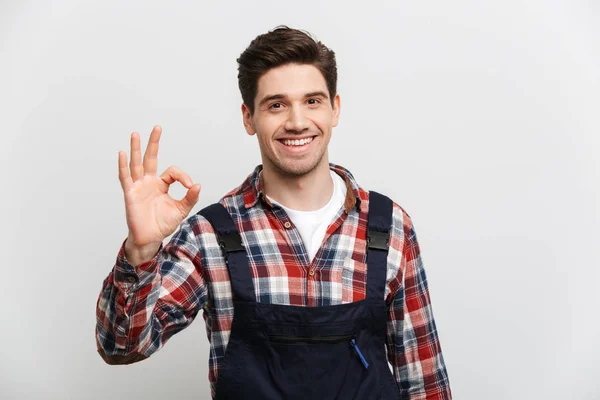 Smiling male builder showing ok sign and looking at camera — Stock Photo, Image