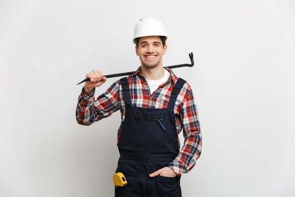 Sorrindo construtor masculino no capacete de proteção segurando pé de cabra — Fotografia de Stock