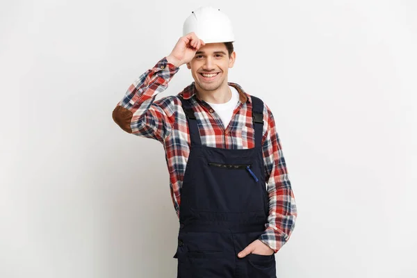 Constructor masculino sonriente en casco protector mirando a la cámara — Foto de Stock