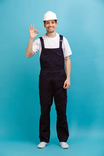 Imagem de comprimento total do Construtor masculino sorridente no capacete de proteção — Fotografia de Stock