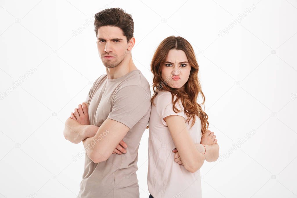 Offended guy and girl wearing beige t-shirts resenting and actin