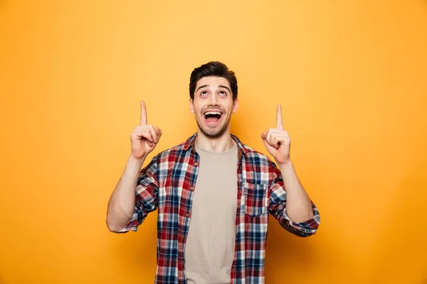 Porträt eines aufgeregten jungen Mannes, der mit dem Finger nach oben zeigt — Stockfoto