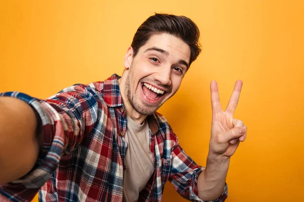 Retrato de um jovem alegre tomando uma selfie — Fotografia de Stock