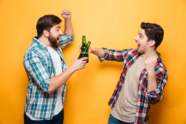 Porträt zweier glücklicher junger Männer, die mit Bier anstoßen — Stockfoto
