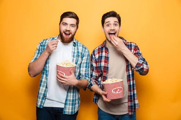 Porträtt av en två lyckliga unga män äta popcorn — Stockfoto