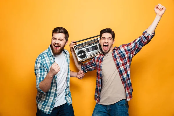 Dois homens brincalhões de camisas ouvindo música por gravador — Fotografia de Stock