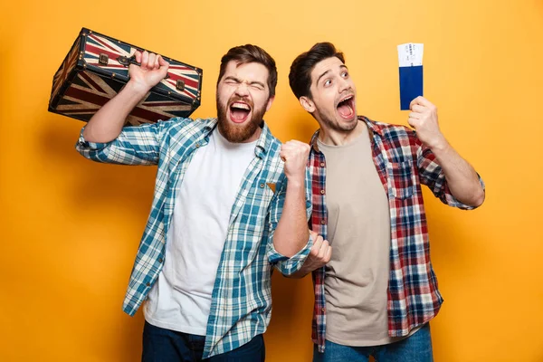 Two happy men in shirts standing with suitcase and passport — Stock Photo, Image