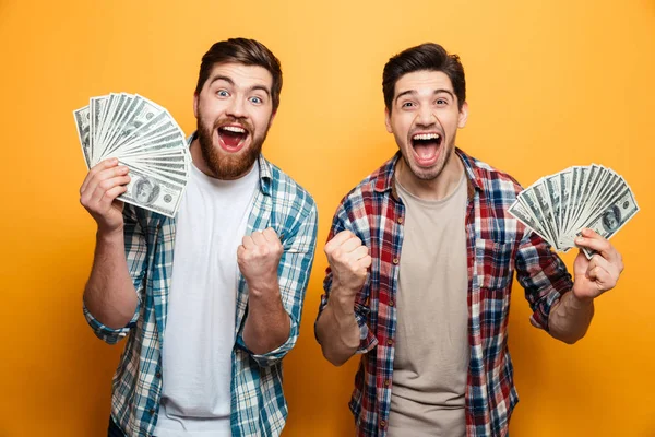 Dos hombres alegres con camisas sosteniendo el dinero y se regocija —  Fotos de Stock