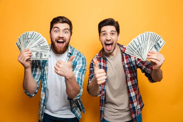 Porträt zweier fröhlicher junger Männer, die Geld zeigen — Stockfoto