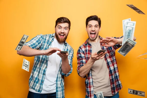 Portrait of a two happy young men scattering money — Stock Photo, Image