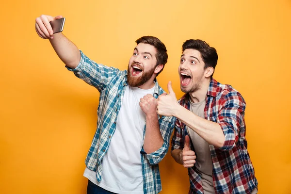 Retrato de dois jovens excitados tirando uma selfie — Fotografia de Stock