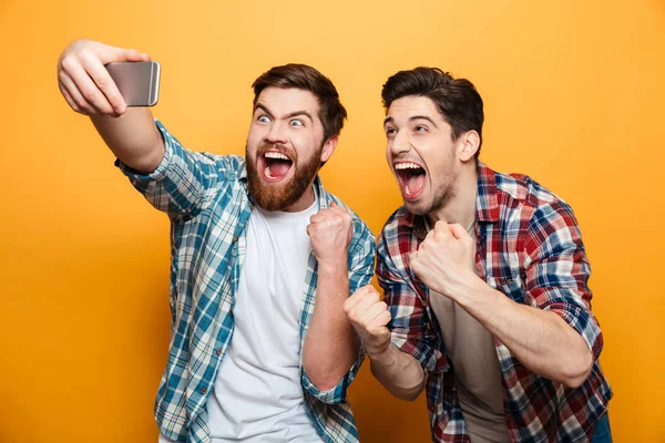 Retrato de dos jóvenes alegres tomando una selfie — Foto de Stock
